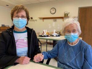 Wesley Health Care Center resident Grace Jackson (right) visits with Marge Rodriguez (left)