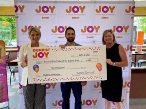 Dunkin’ Operations Manager Nicole Pecori (left) and Westside Donuts, a Dunkin’ franchisee network, Director of Operations Gretchen Cantwell (right) present Boys & Girls Clubs of the Capital Area Chief Executive Officer Justin Reuter (center) with a $10,000 grant.