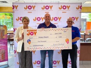 Dunkin’ Operations Manager Nicole Pecori (left) and Dunkin’ Field Marketing Manager Eric Stensland (right) present Victory Church Chief Financial Officer Mark Pratt (center) with a $5,000 grant.